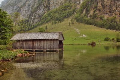 Barn at lakeshore against mountain