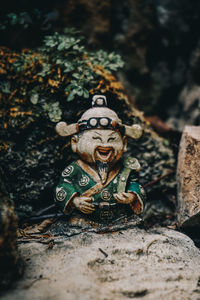 Close-up of buddha statue on rock