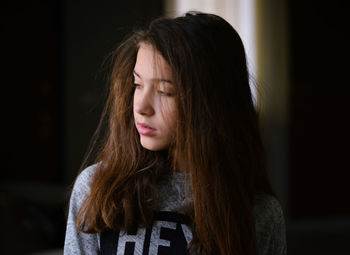 Close-up of woman looking away while standing indoors