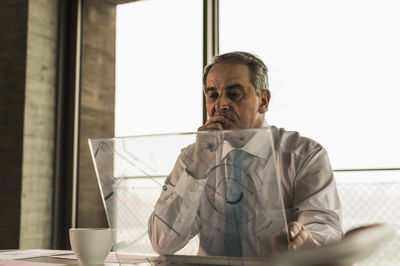 Senior manager in office using futuristic computer