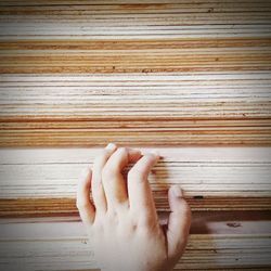 Close-up of hand on wooden floor