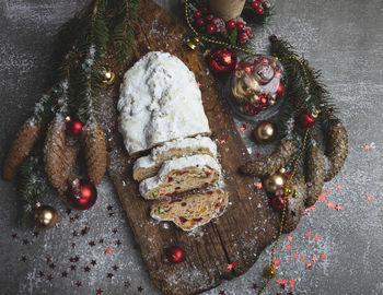 Traditional christmas stollen, cones, branches of a tree and christmas decorations, pastry dessert