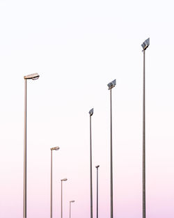 Low angle view of street lights against clear sky during sunset
