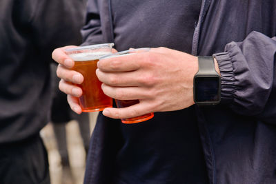 Midsection of man holding beer