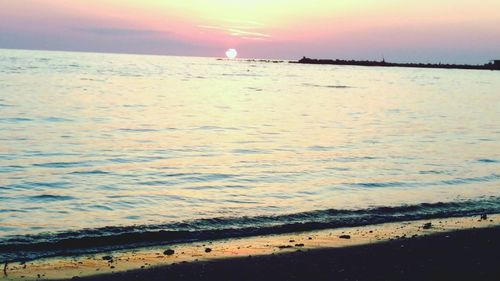 Scenic view of beach against sky during sunset