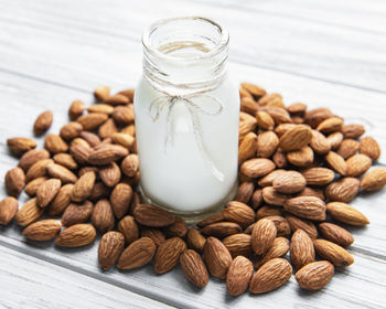 Almond milk with almonds on a wooden table