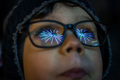 Close-up of young child wearing eyeglasses with weel reflection