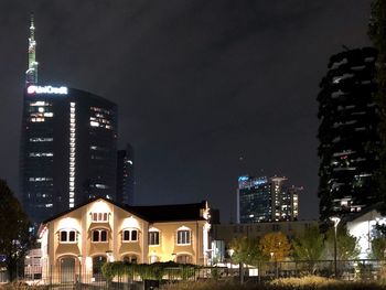 Illuminated buildings against sky at night