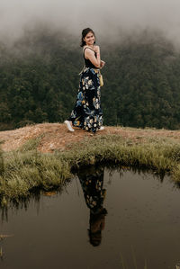 Young woman standing by lake