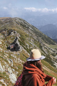 Rear view of man looking at mountain against sky