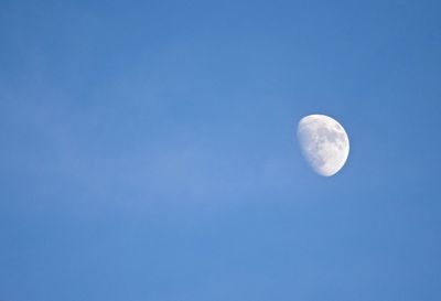 Low angle view of moon against clear blue sky