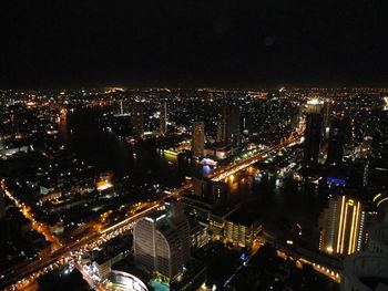 Illuminated cityscape against sky at night