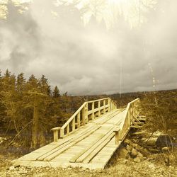 Footbridge over land against sky