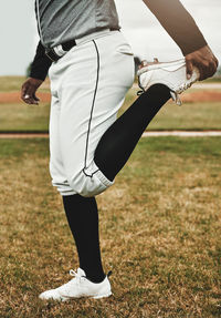 Low section of woman standing on field