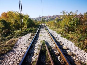 Railroad track amidst trees against clear sky