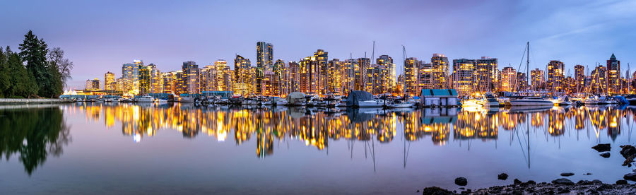 Panoramic view of sailboats in city by buildings against sky