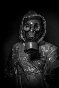 Man wearing gas mask against black background