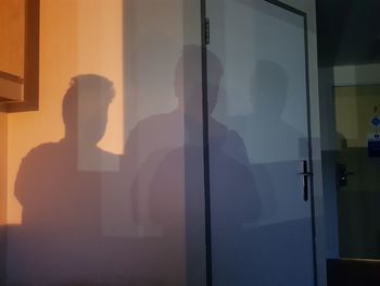 Side view of woman standing by door