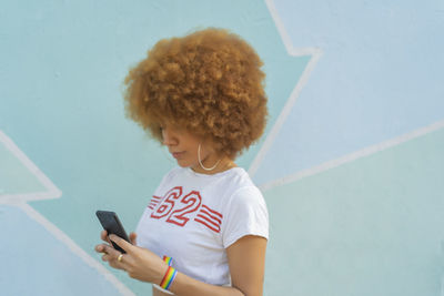 Woman with afro hair using her smartphone