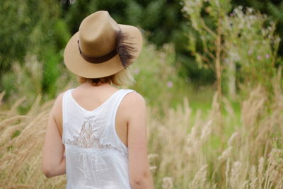 Woman wearing hat standing on field