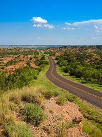 Aerial view of country backroad to the distant horizon of the texas hill country under a blue sky