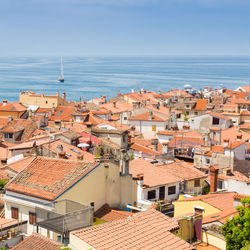 High angle view of townscape by sea against sky