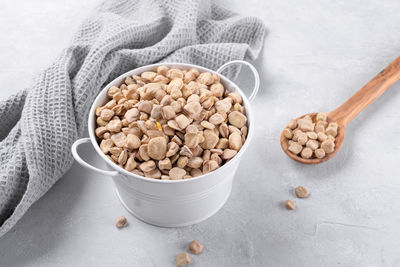 Cicerchia or indian pea in a white bowl with napkin on grey table background, gluten free food