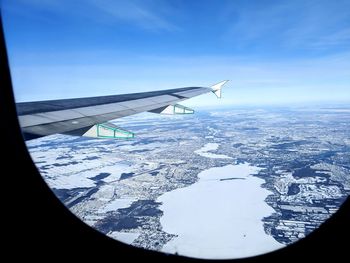 Airplane flying over snowcapped mountain against sky