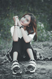 Portrait of young woman sitting outdoors