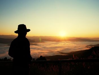 Silhouette man looking at sunset