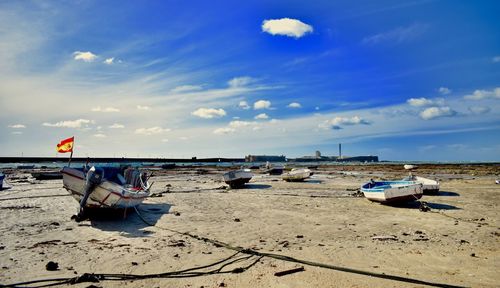 Boats moored on beach against sky