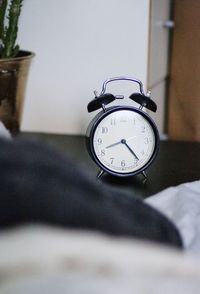 Close-up of clock on bed at home