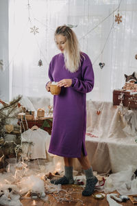 Full length of woman standing amidst christmas decoration
