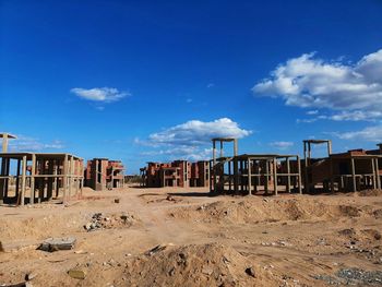 View of abandoned building on beach against blue sky