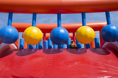 Man sitting by large balls falling from water slide