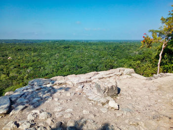 Scenic view of land by sea against sky