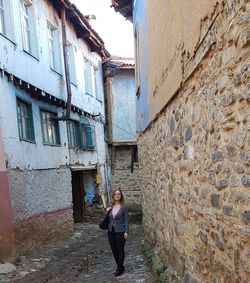 Full length of woman standing in front of old building