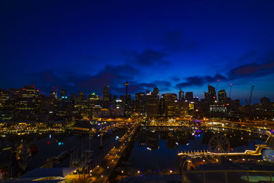 Illuminated cityscape against sky at night