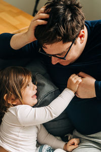 Father playing with daughter at home