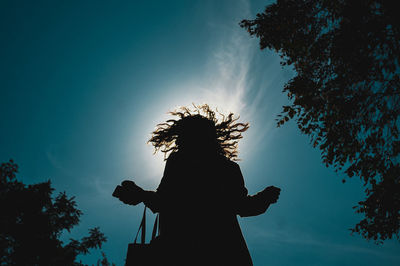 Low angle view of silhouette woman against sky