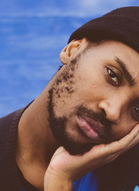 Close-up portrait of man with hand on cheek