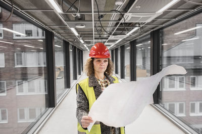 Female worker looking at blueprints