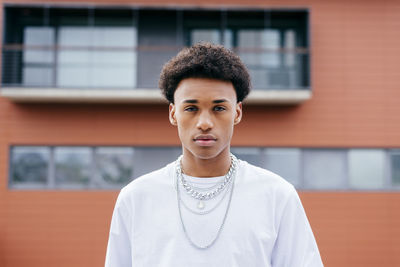 Portrait of teenage boy standing against building