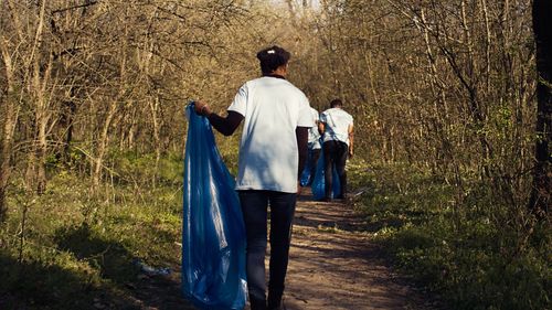 Rear view of woman walking in forest