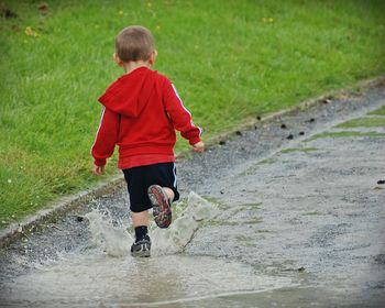 Rear view of boy playing in puddle