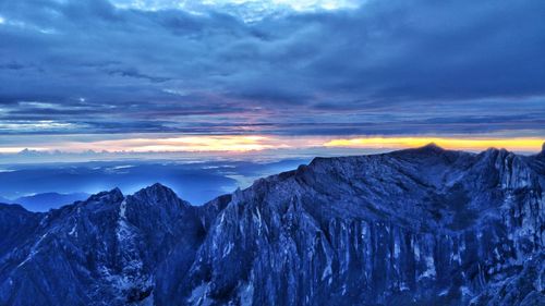 Scenic view of snowcapped mountains against sky during sunset