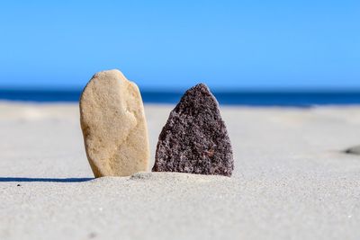 Close-up of stones on beach against clear sky