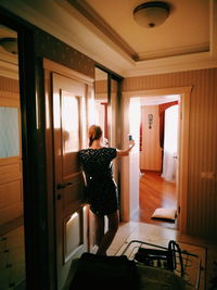 Rear view of woman standing at home