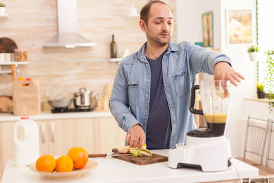 Young man making juice at home