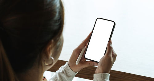 Midsection of woman holding mobile phone